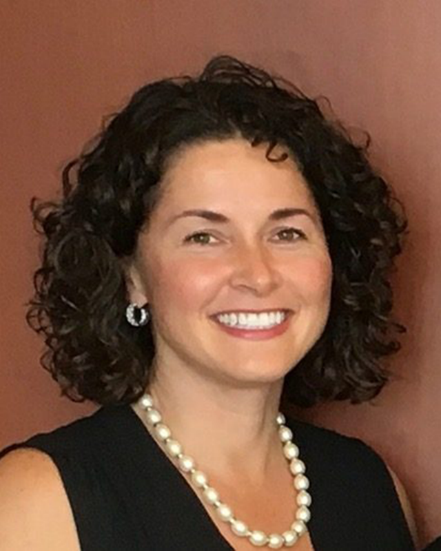 woman with dark curly hair smiling