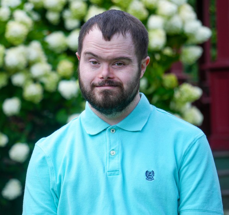 young man with beard, glasses, and blue collared shirt
