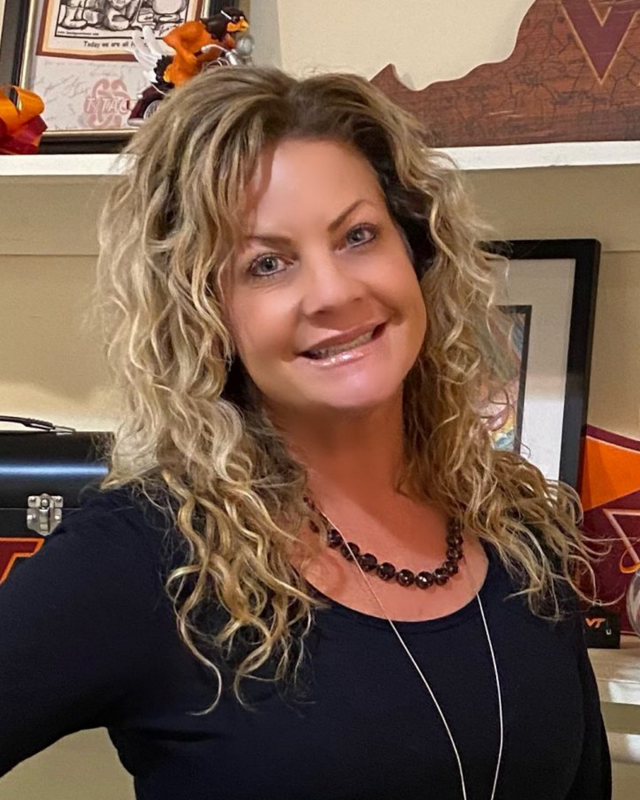 woman with curly blonde hair and black shirt