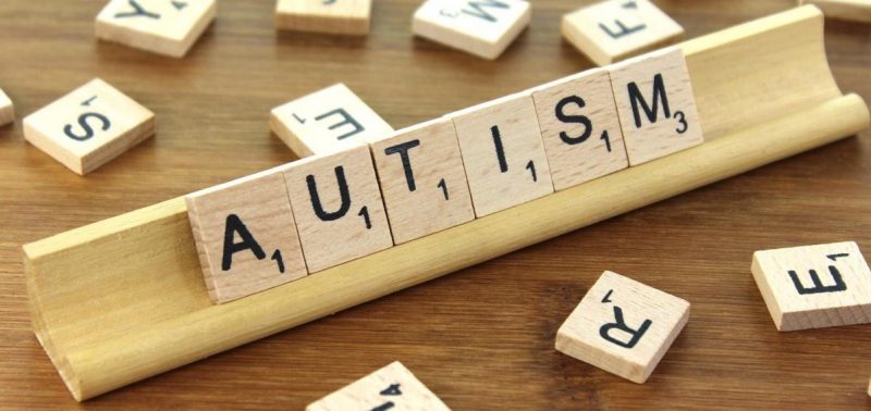 Image of the word Autism spelling out with wooden Scrabble tiles